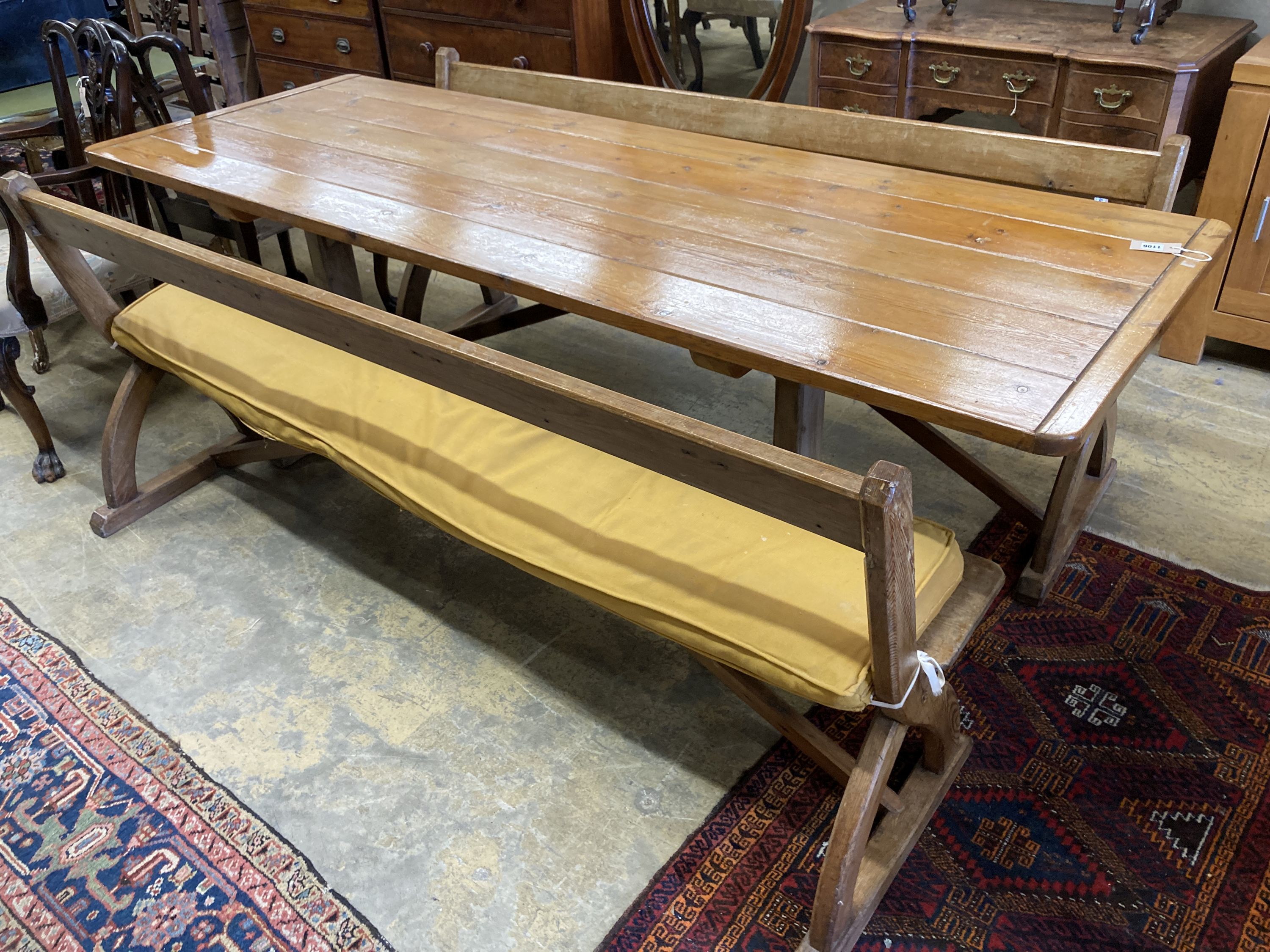 A rectangular pine kitchen table, width 218cm, depth 77cm, height 77cm together with a pair of Victorian pitch pine bench seats